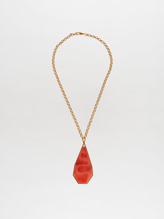 The Ascoli Necklace by Silvia Tcherassi features a gold chain with a smooth red teardrop pendant showcased against a white background, ready to dazzle once ordered.