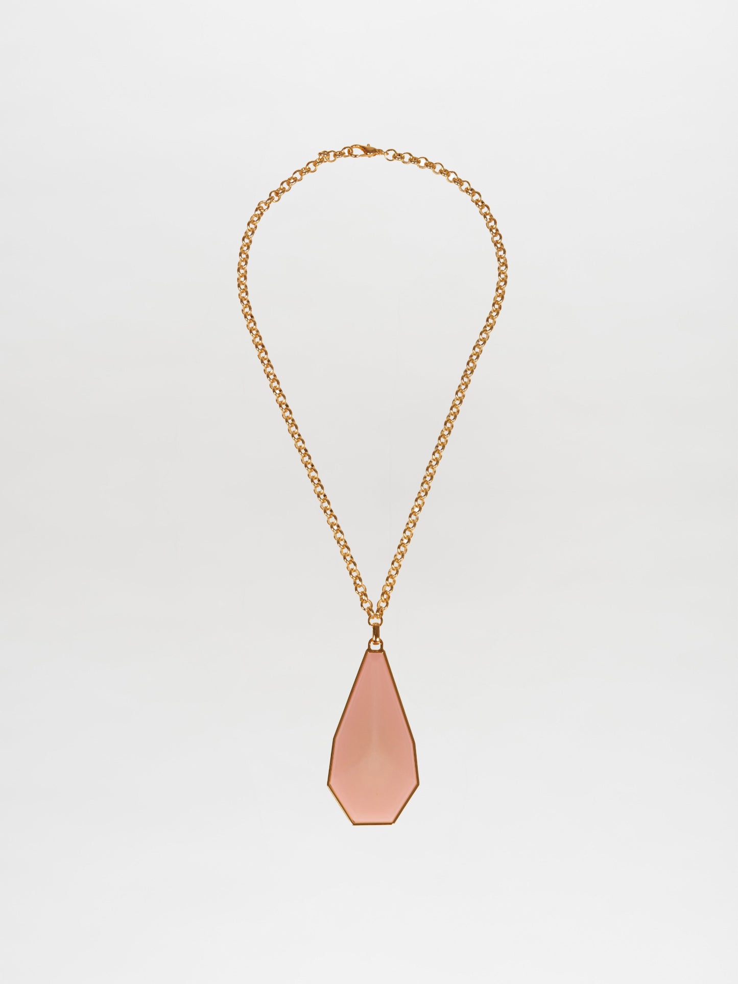 The Ascoli Necklace by Silvia Tcherassi, featuring a gold chain and geometric teardrop-shaped pink pendant, is elegantly showcased on a plain white background. Ideal for any occasion, this exquisite piece ensures swift shipping and minimal processing time for your convenience.