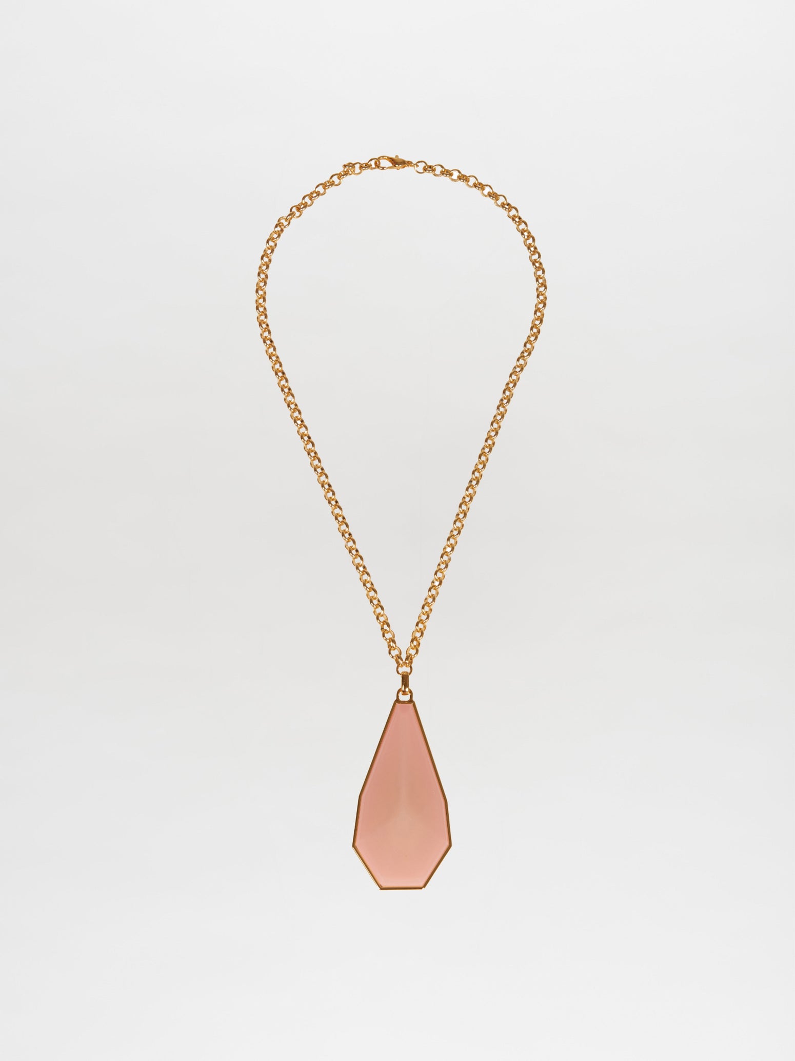 The Ascoli Necklace by Silvia Tcherassi, featuring a gold chain and geometric teardrop-shaped pink pendant, is elegantly showcased on a plain white background. Ideal for any occasion, this exquisite piece ensures swift shipping and minimal processing time for your convenience.