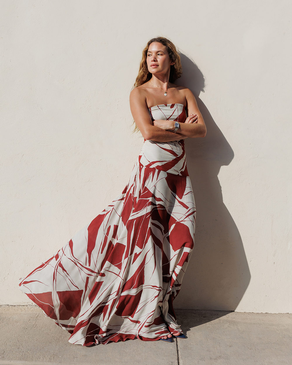 Woman wearing a strapless red and white patterned dress against a light background