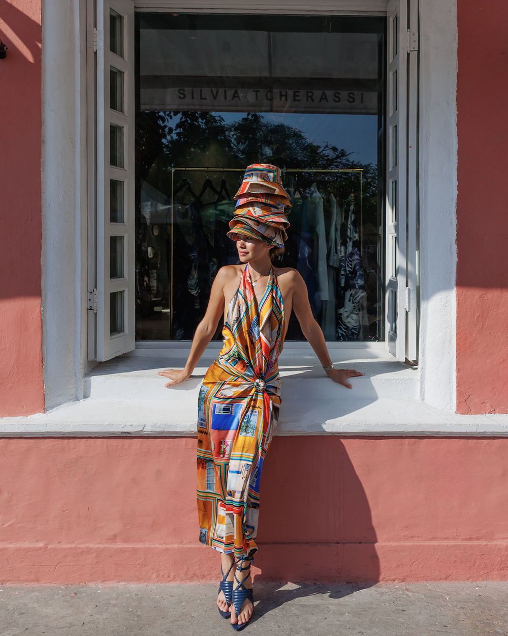 Woman in a colorful outfit standing in front of a store with 'Silvia Tcherassi' branding.
