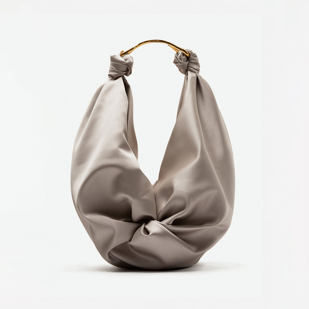 Elegant taupe knotted handbag with a twisted gold handle. The smooth, draped texture gives a luxurious and sophisticated feel.