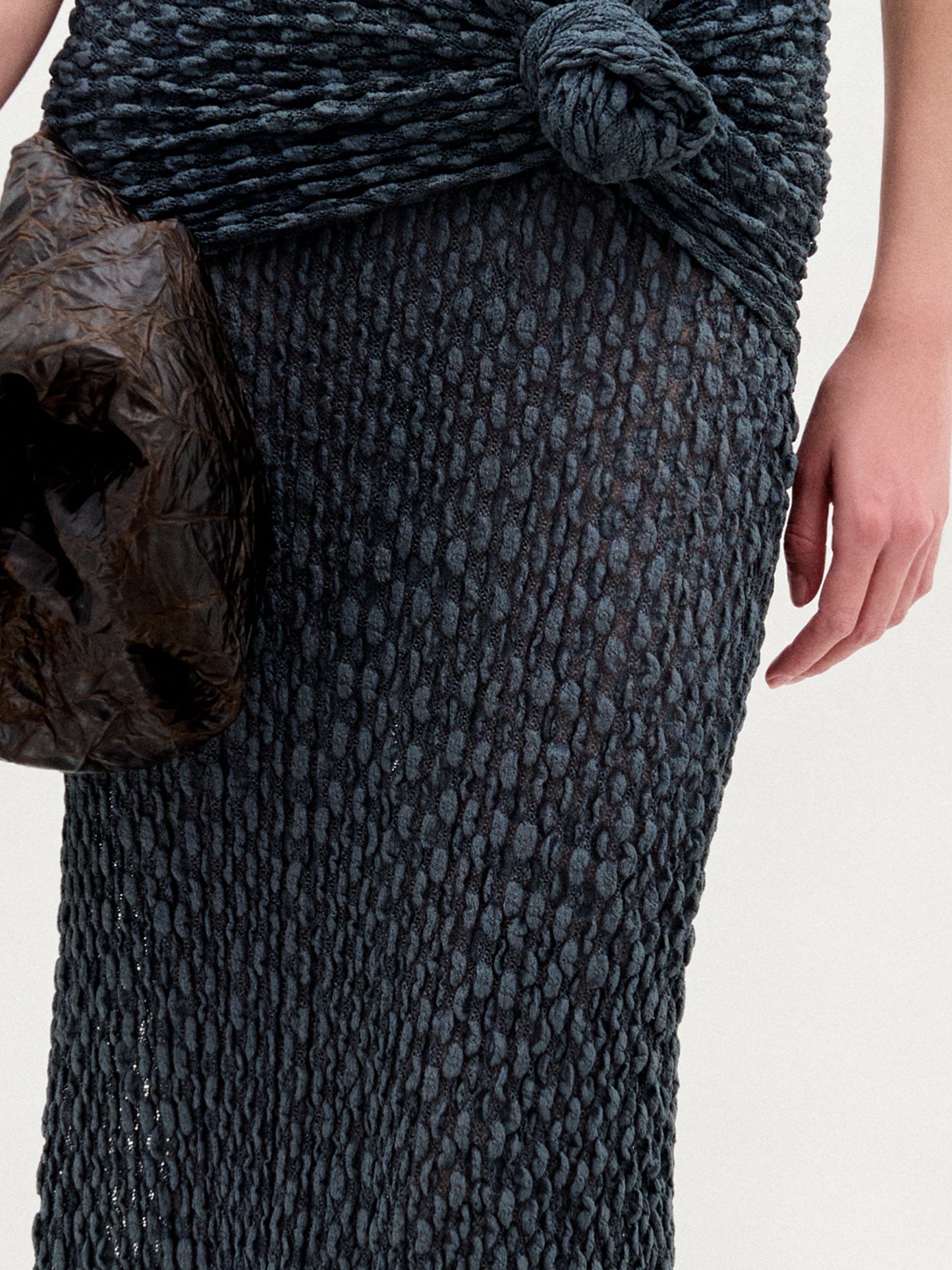 A woman wearing the Ciji Skirt in color Deep Gray with a Sofia Bag Maxi in color Cacao on a white background.