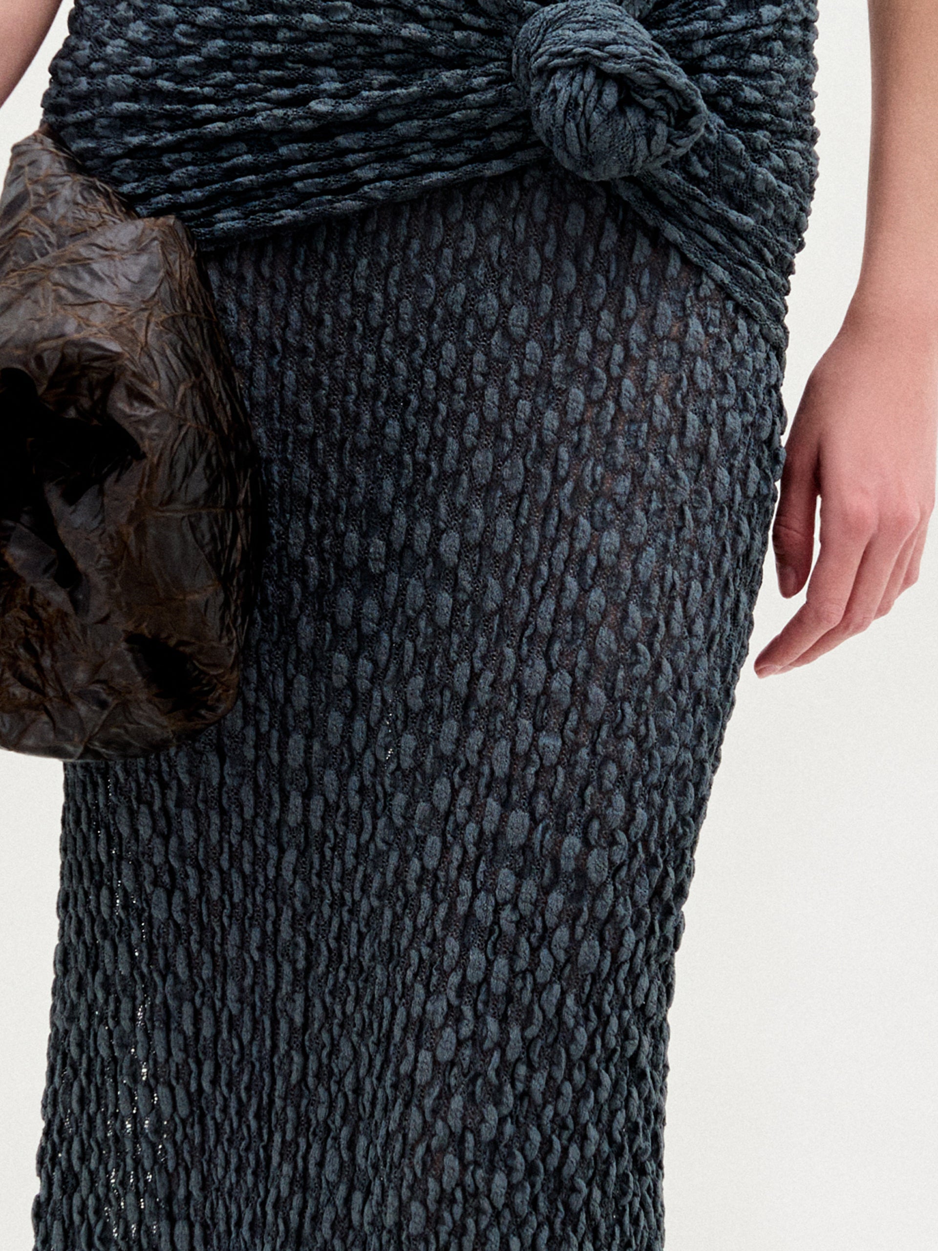 A woman wearing the Ciji Skirt in color Deep Gray with a Sofia Bag Maxi in color Cacao on a white background.