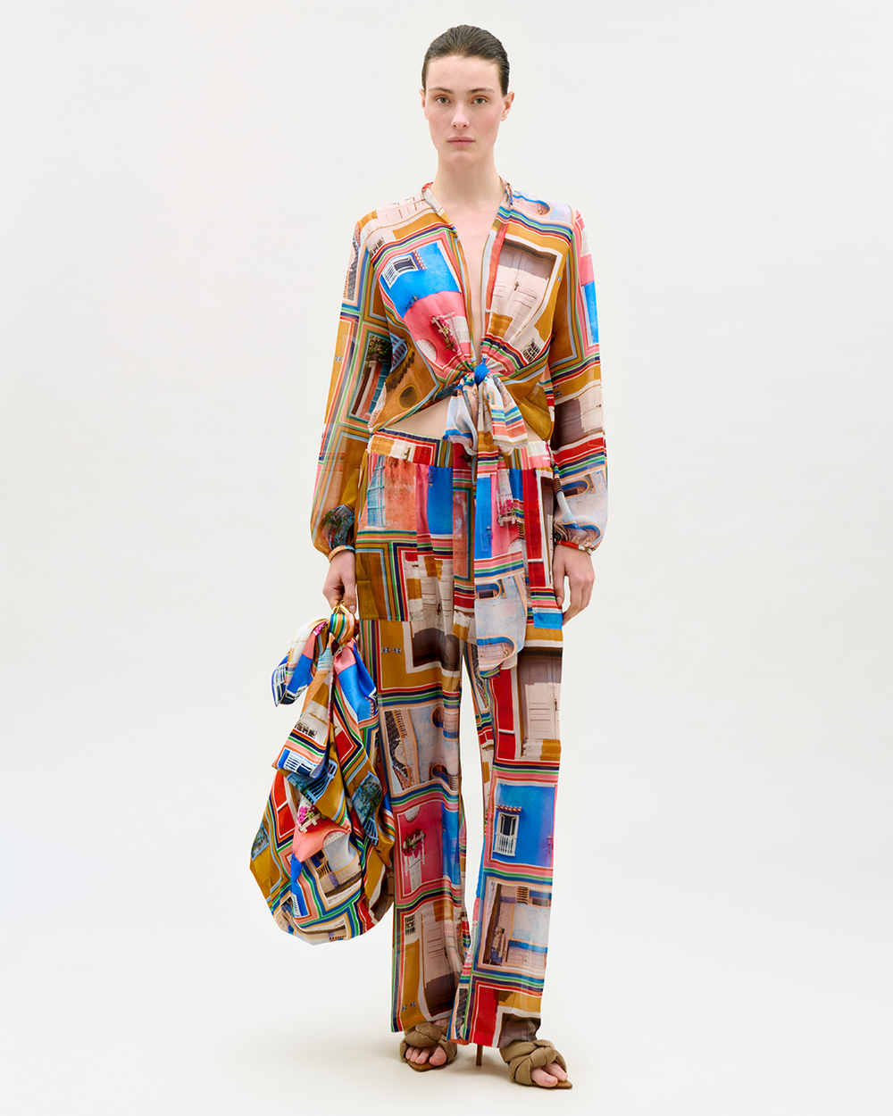 Model wearing a colorful patchwork outfit on a white background