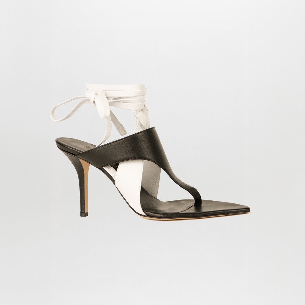 The Domenico Heels Black/White by SilviaTcherassi feature Italian leather in black and white, an open toe, thong strap, and ankle wrap tie—an elegant sandal shown against a plain light background.