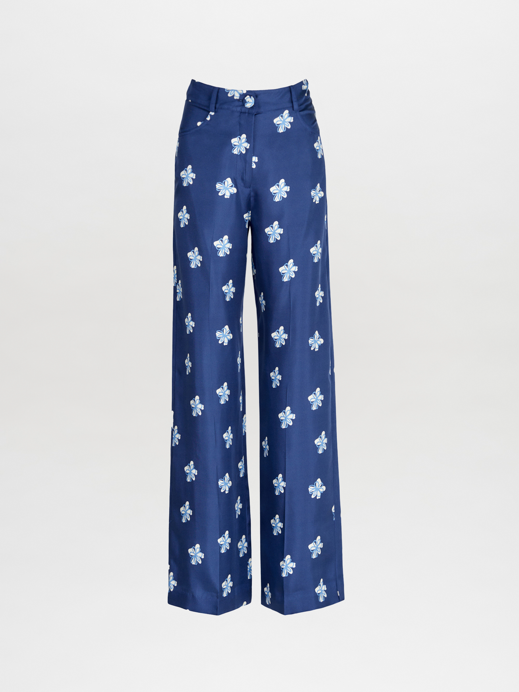 The Emine Pant by Silvia Tcherassi features a high-waisted, wide-leg silhouette in blue with an all-over white and light blue floral pattern, shown against a plain white background.