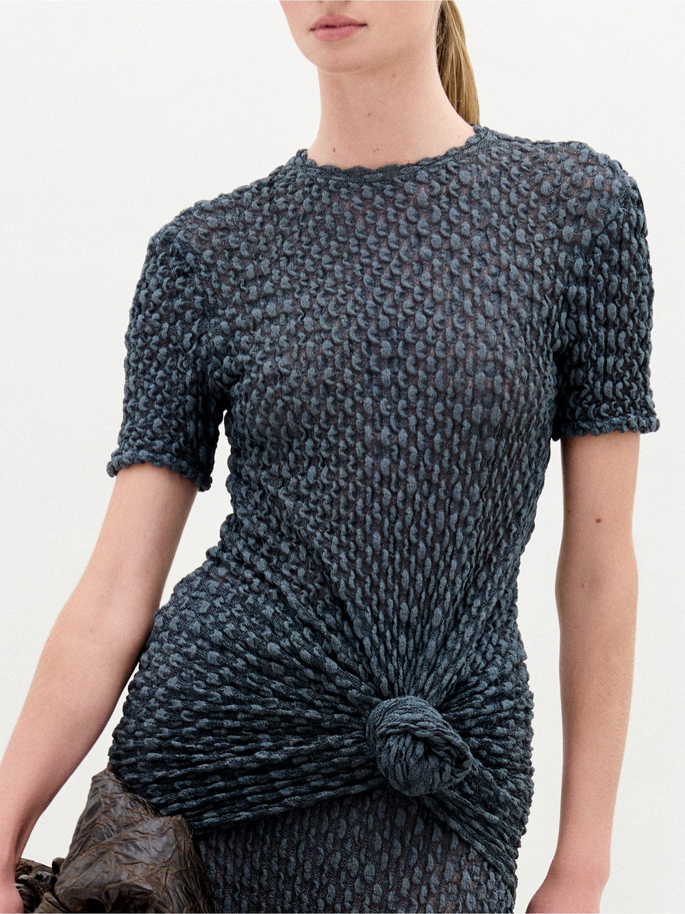 A person wearing the Gen Tshirt in color Deep Gray with a Sofia Bag Maxi in color Cacao on a white background.