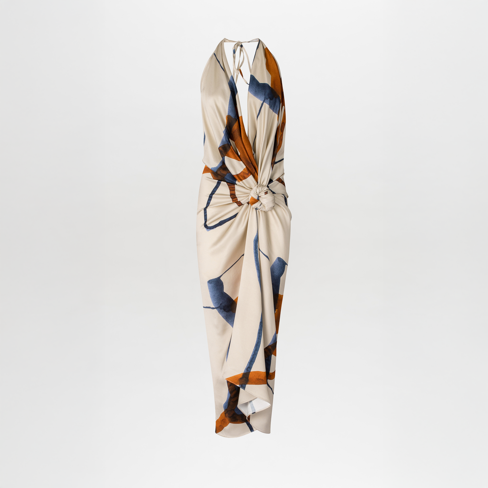 The Guadalupe Dress by SVT DESIGNS is a sleeveless beige midi with a knotted front and draped silhouette, adorned with an abstract blue and brown multicolor print, shown against a white background.