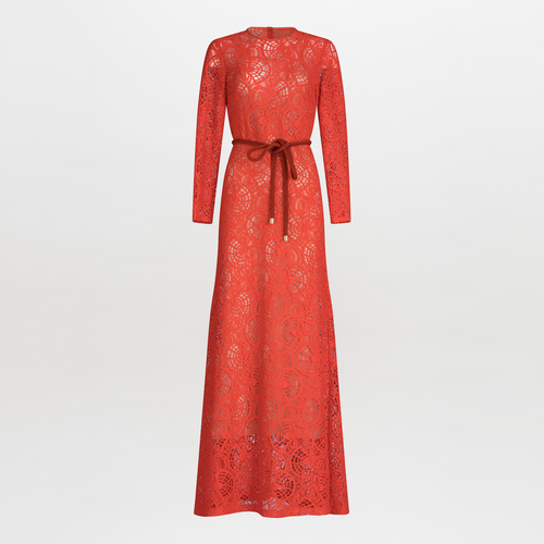 The Ida Dress by SVT DESIGNS is a long-sleeved, full-length red lace dress with intricate floral patterns, a flattering A-line skirt, and a round neckline. It includes a matching red belt at the waist and is photographed against a plain white background.