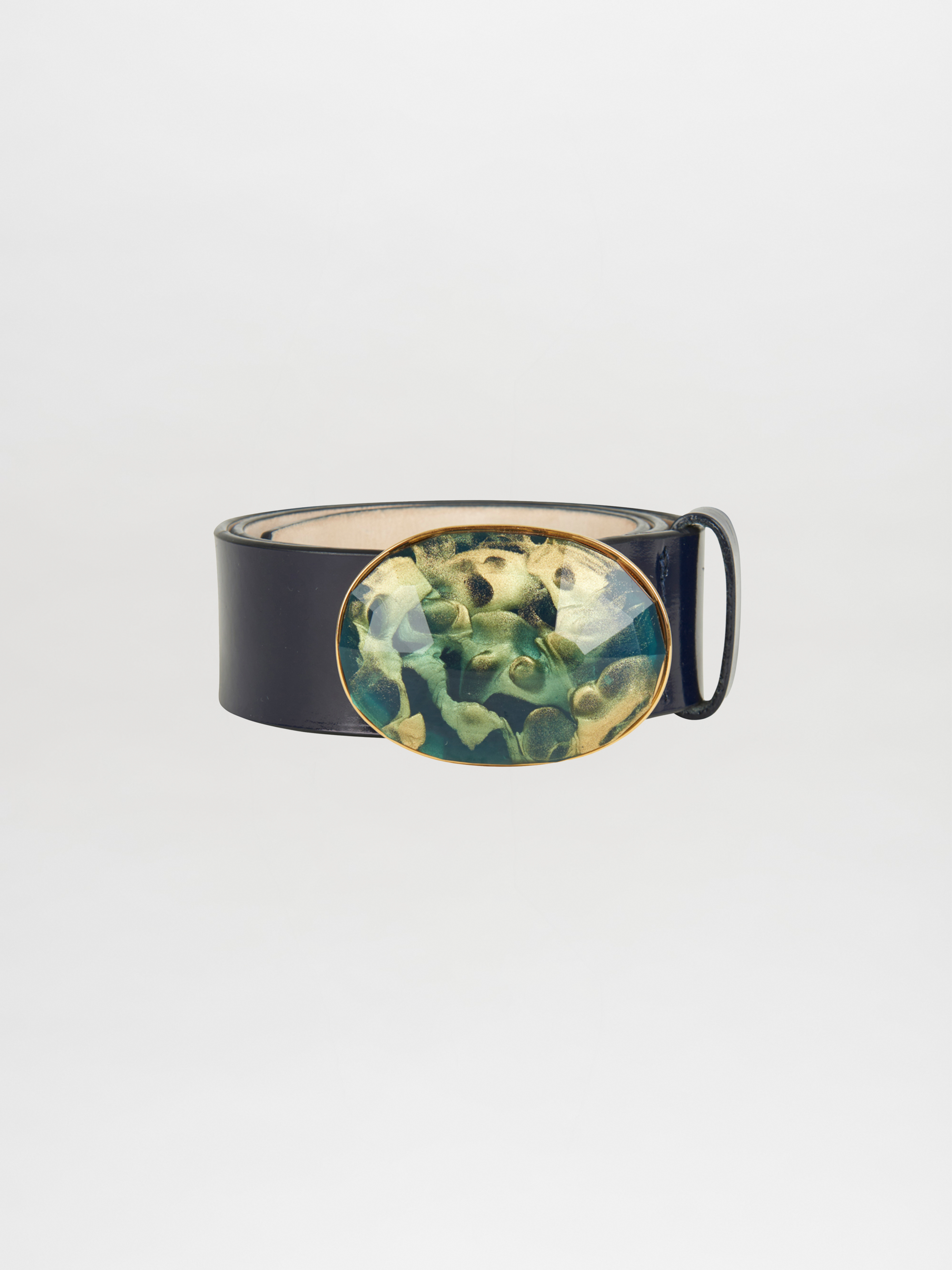 The Irene Belt Navy by Silvia Tcherassi is an Italian leather accessory featuring an oval resin buckle with a vibrant abstract design in shades of green and gold on a white background, ideal for Fall 2023.