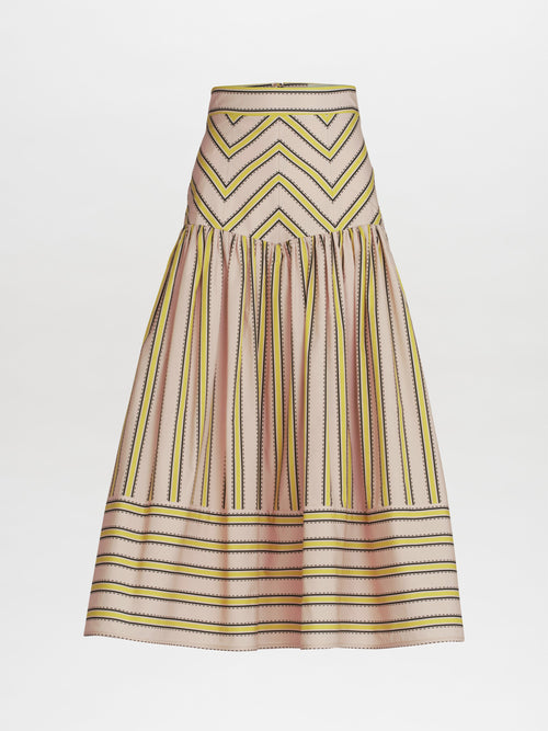 The Kristina Skirt by SVT DESIGNS is a high-waisted midi featuring a chevron pattern above vertical stripes, made from luxurious Italian fabric. It showcases light pink, yellow, and black hues on a neutral base with a flattering gathered waist and falls elegantly to the knee.