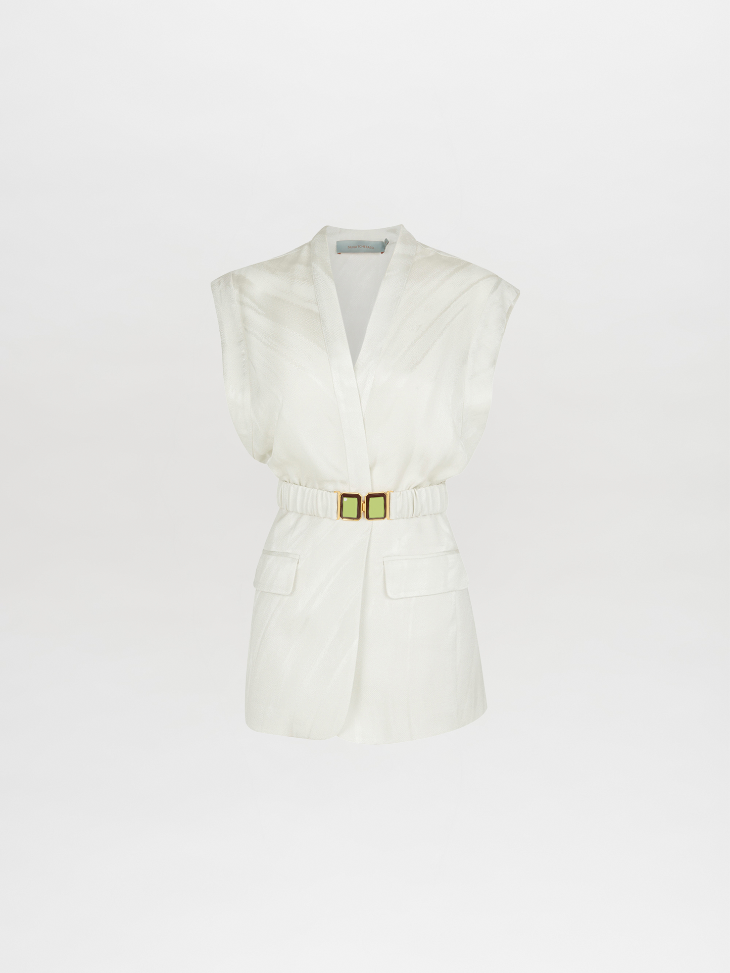 The Silvia Tcherassi Keith Vest Moonstone is a modern, elegant sleeveless white blazer with a deep V-neck, waist-cinching gold buckle belt, and two front flap pockets on moonstone jacquard.