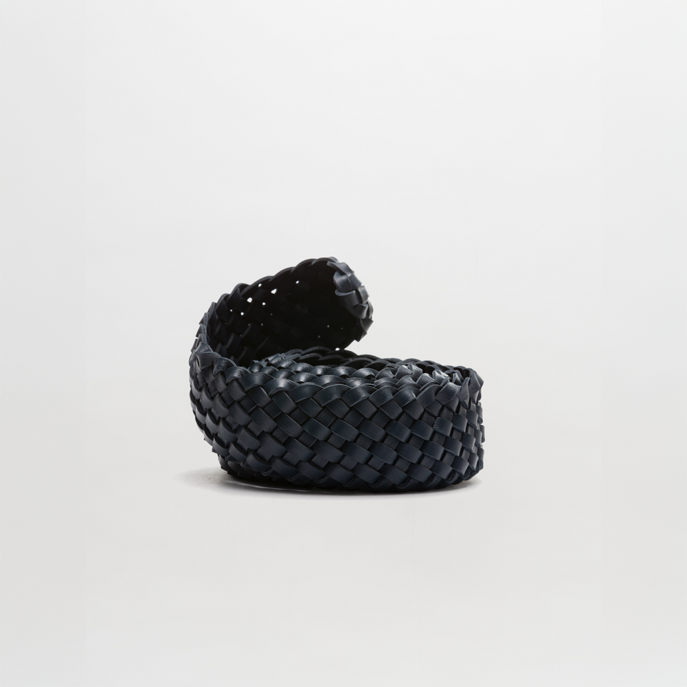 The Lauren Belt by SVT DESIGNS, crafted from 100% black leather with a woven texture and partially curved open lid, showcases Italian-inspired craftsmanship against a plain white background, casting a subtle shadow.