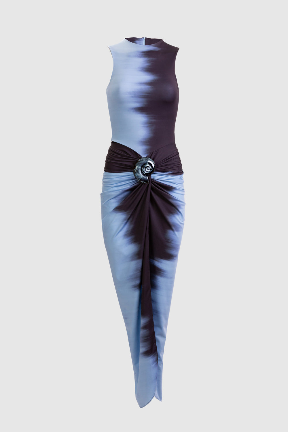 The Leni Dress by SVT DESIGNS is a sleeveless midi with a blue and black tie-dye pattern, fitted bodice, gathered waist with circular buckle, embellished skirt, front center slit, and crafted from premium Italian fabric.
