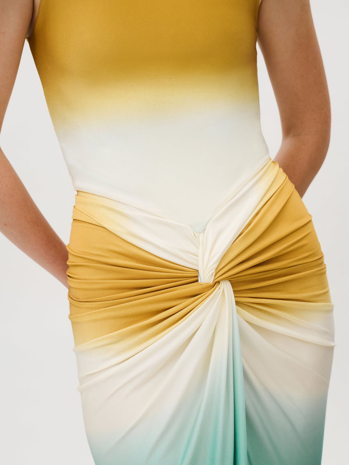 Leni Dress, a sleeveless midi dress in an Italian fabric with a yellow-to-teal ombre gradient and a gathered, knotted detail at the waist.