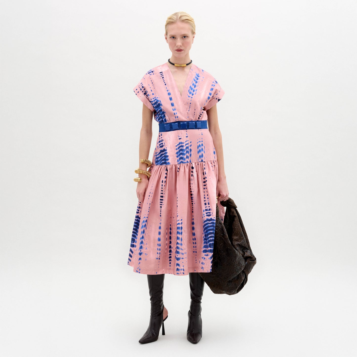 Woman wearing a pink and blue tie-dye dress on a white background