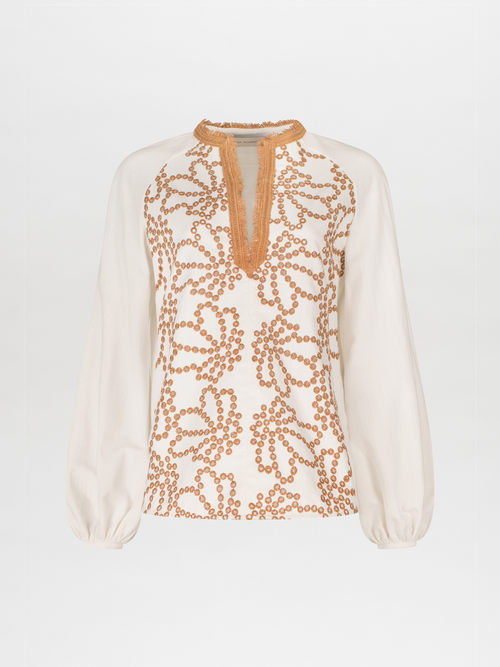 A Molveno Blouse White Cacao Eyelet with orange embroidery and lace detailing.