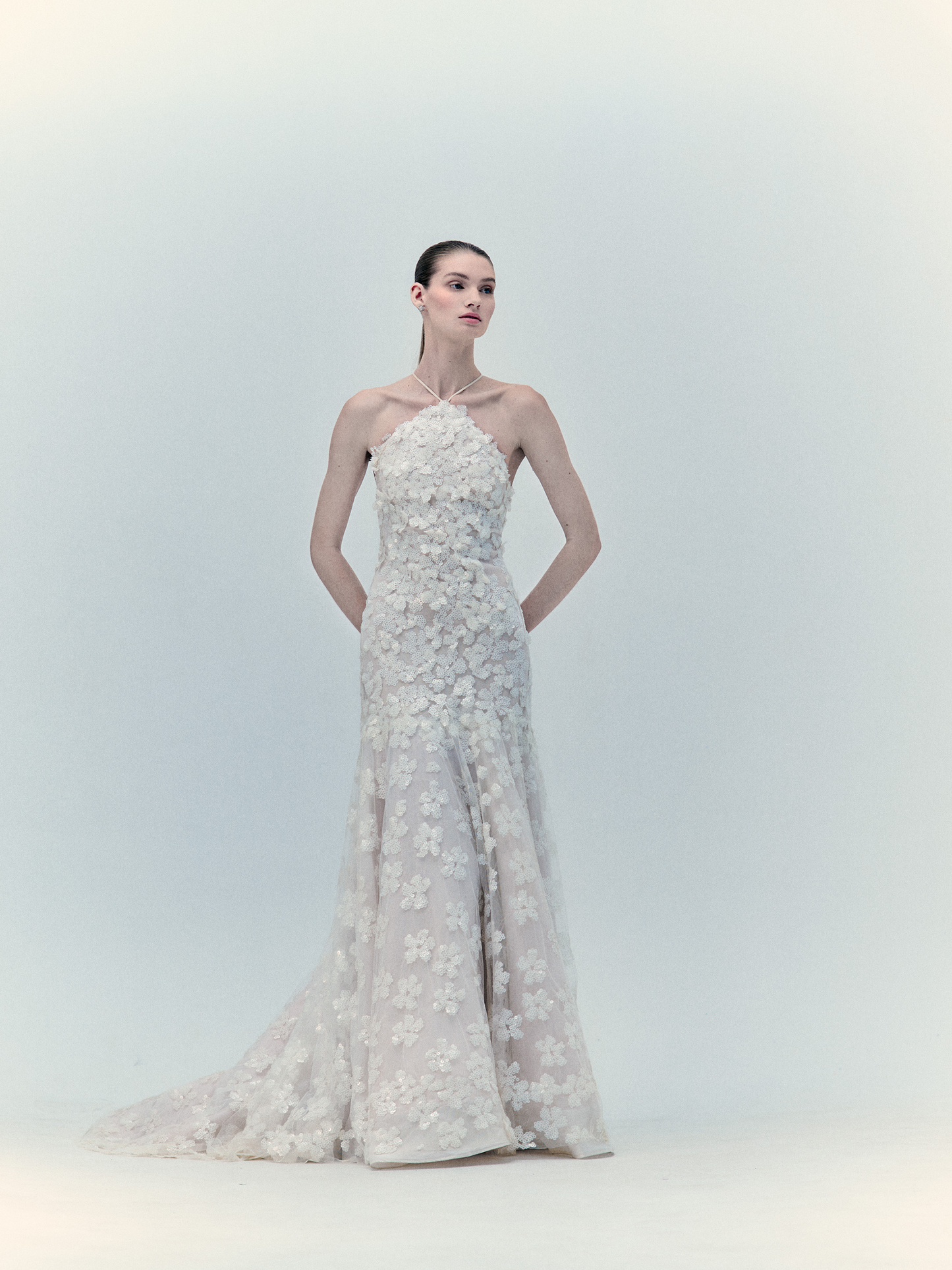 A woman in the Maria Dress Pearl, an exclusive strapless floral gown, posing against a plain background.