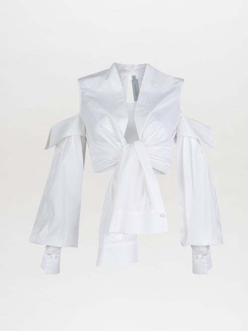 The SilviaTcherassiEU Matinata Top is a deconstructed hero piece with oversized shoulder cutouts. This white, long-sleeved shirt includes a collar, tied front, and buttoned cuffs for a stylish, modern look against a plain white background.