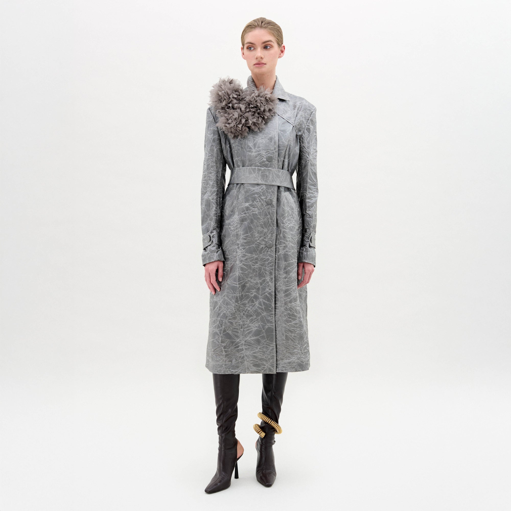 Woman wearing a gray coat with a decorative element on a white background