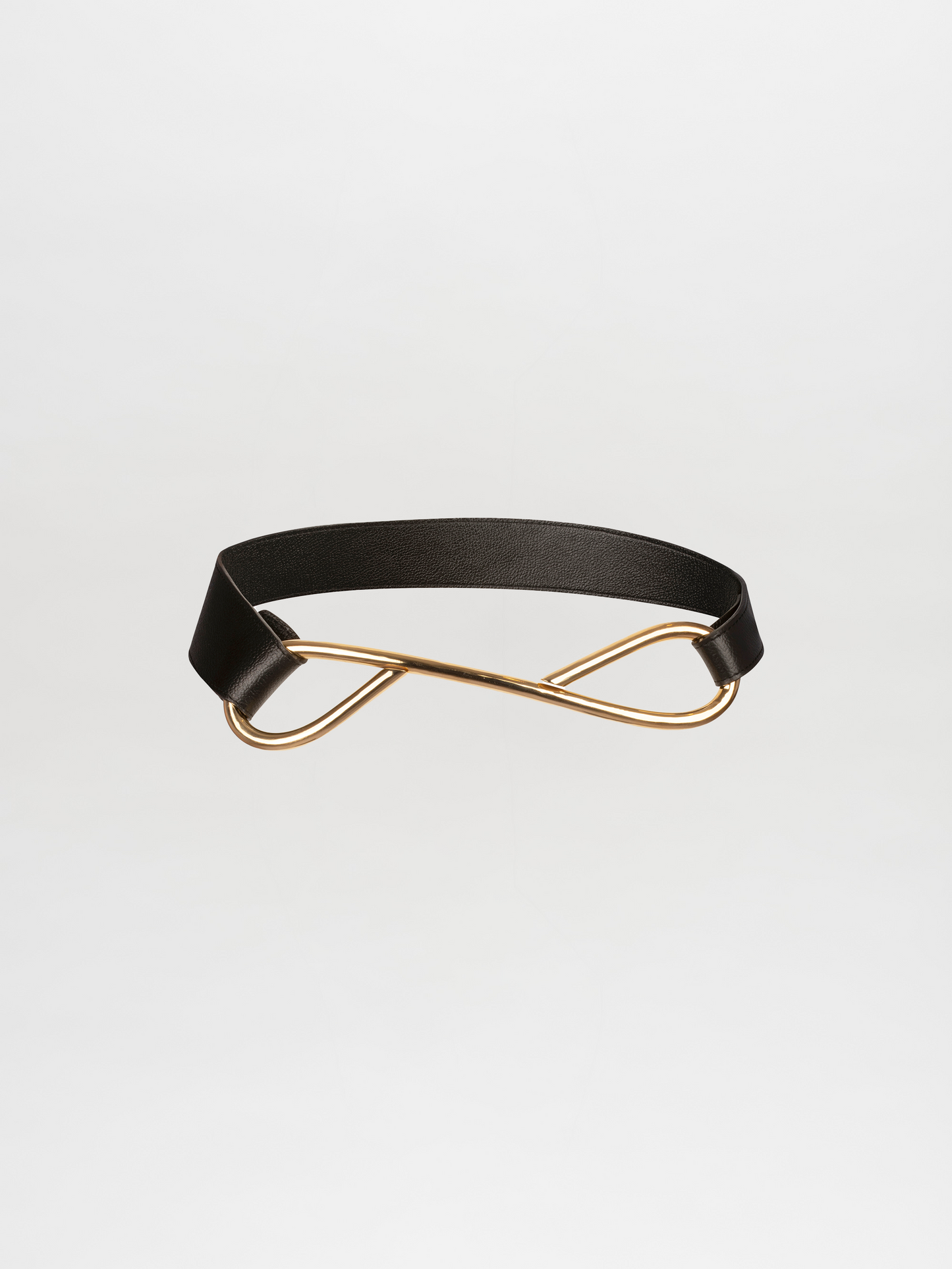 A Odelia Belt Black with a gold interlocking loop design in the center, displayed against a plain white background. Available for pre-order until November 15, secure yours now and it will ship promptly after.