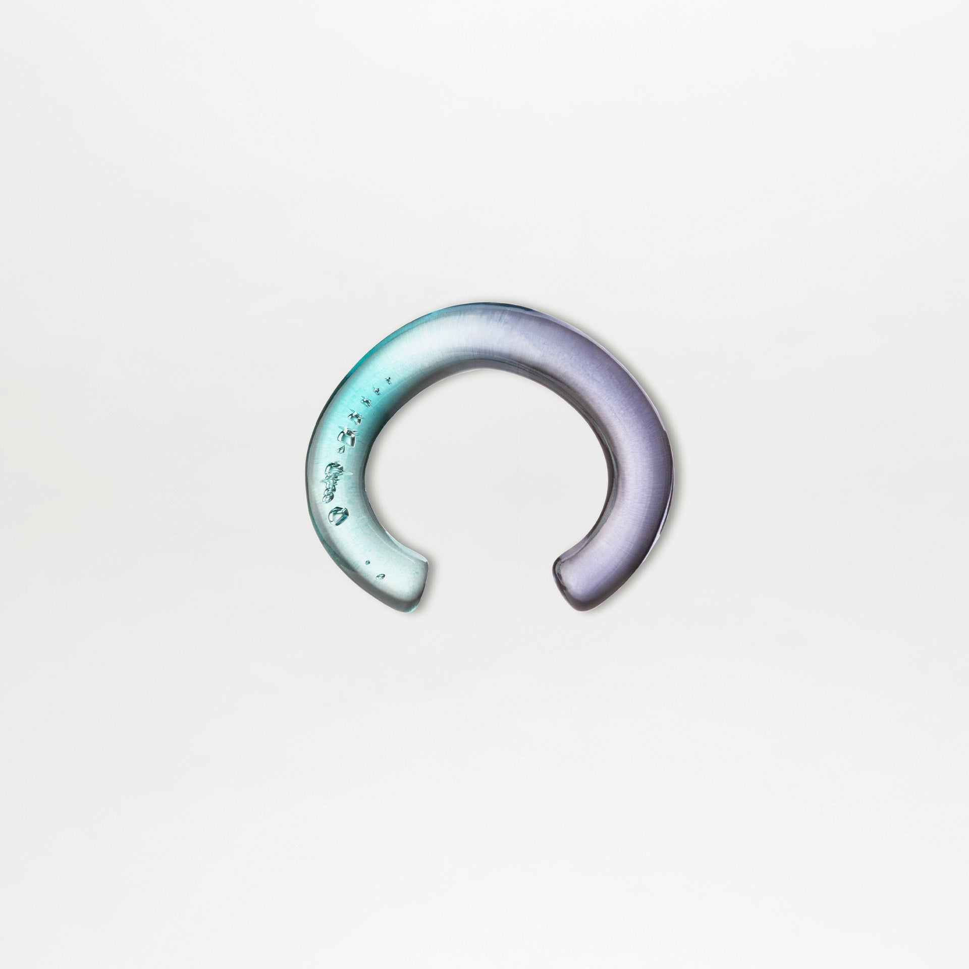 The Oli Bracelet by SVT DESIGNS is a crescent-shaped Italian PMMA acrylic piece, featuring a teal-to-purple gradient with sculptural details and subtle decorative marks at the left end, shown on a plain white background.