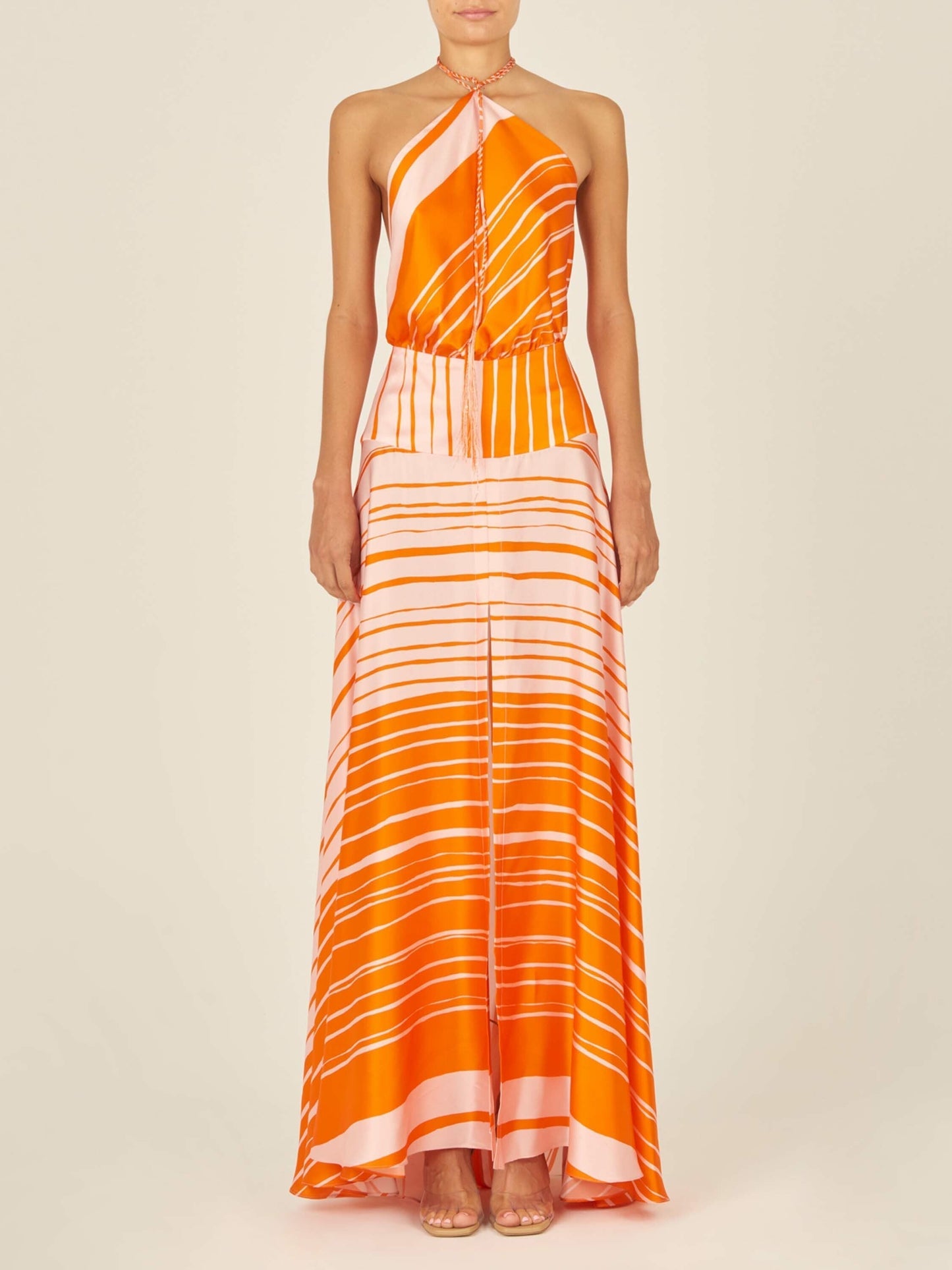 A flattering silhouette of an Agnese Dress Orange Pink with a halter neckline reminiscent of Silvia Tcherassi designs.