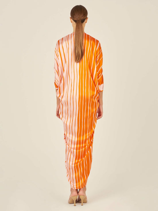 An Cloister Dress Orange Pink with a festive print on a mannequin.