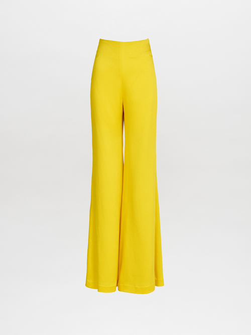 The Palermo Pant Yellow by Silvia Tcherassi is shown on a plain white background. These bright yellow, high-waisted wide-legged flare pants are made from hammered satin, featuring a smooth fabric and flared silhouette without patterns or embellishments.