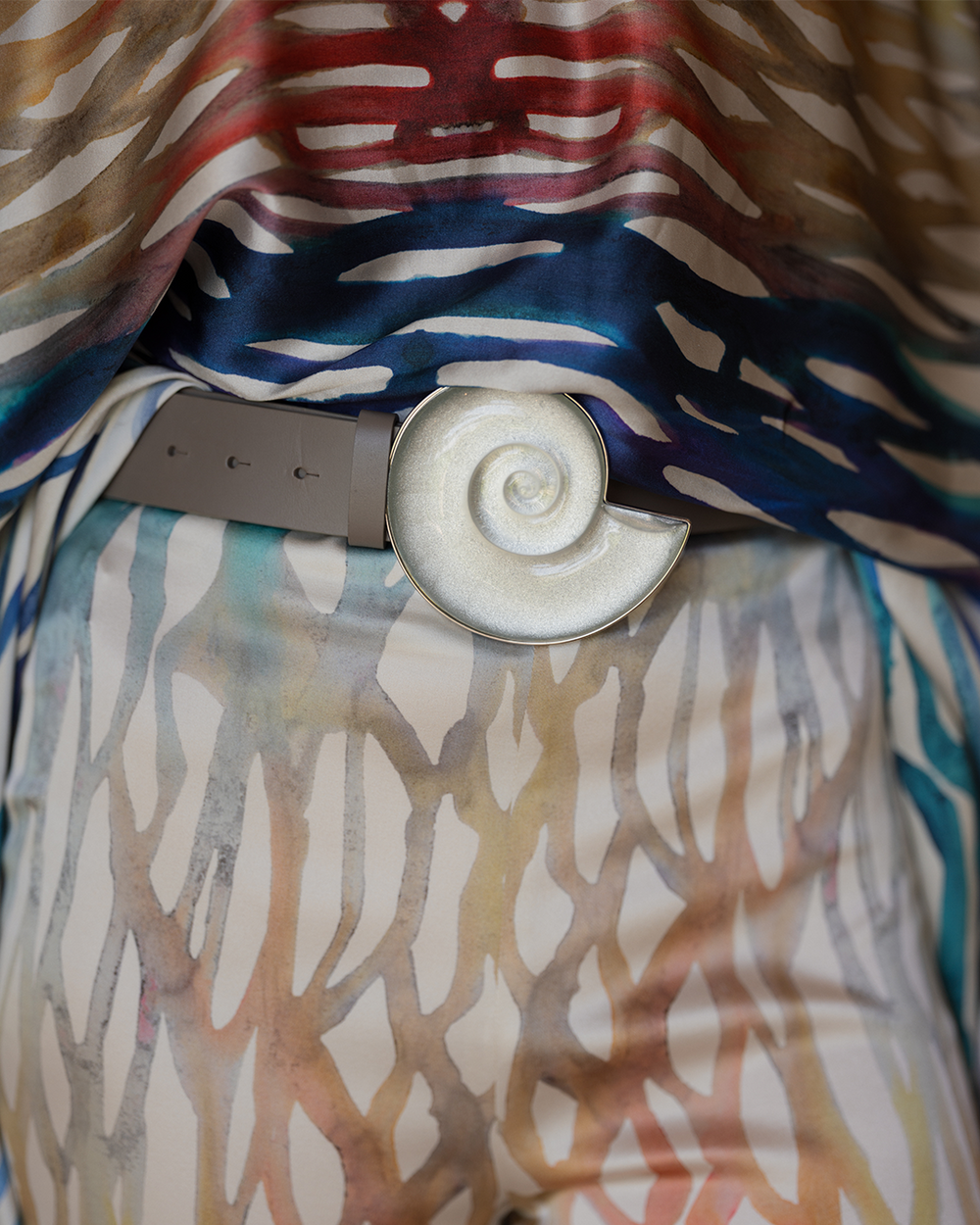 Colorful patterned fabric with a belt and circular object on top