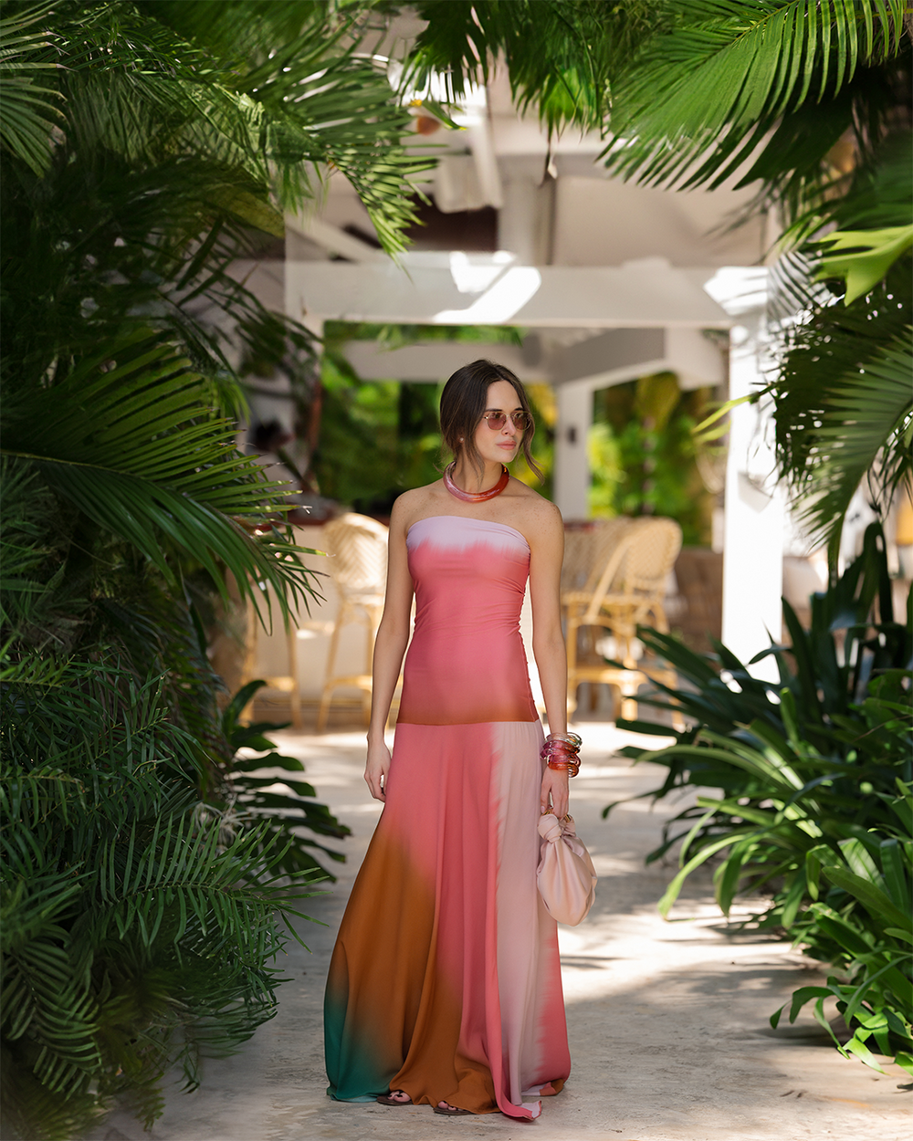 Woman in a colorful dress standing among tropical plants