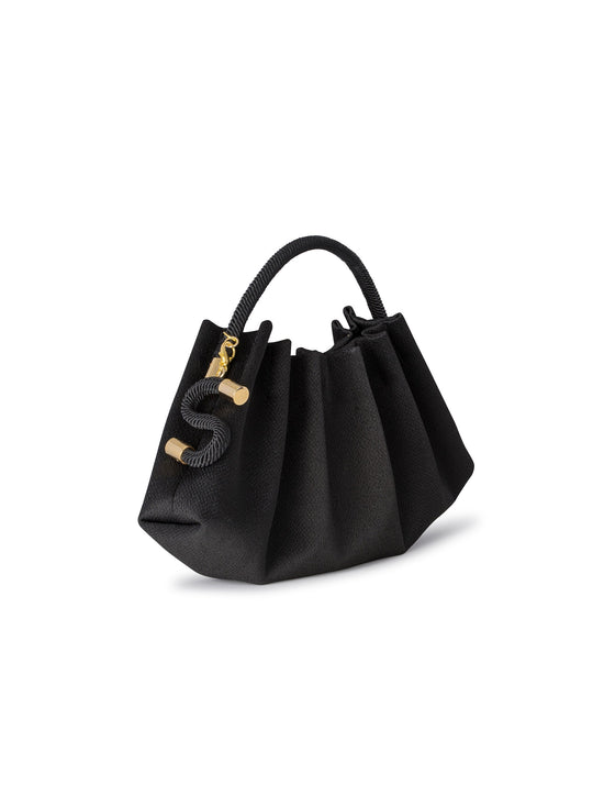 The ST Clutch Black handbag features a textured surface, gold hardware, and a short braided handle. It boasts a gathered design and drawstring closure. Please refer to the item ship date upon ordering.