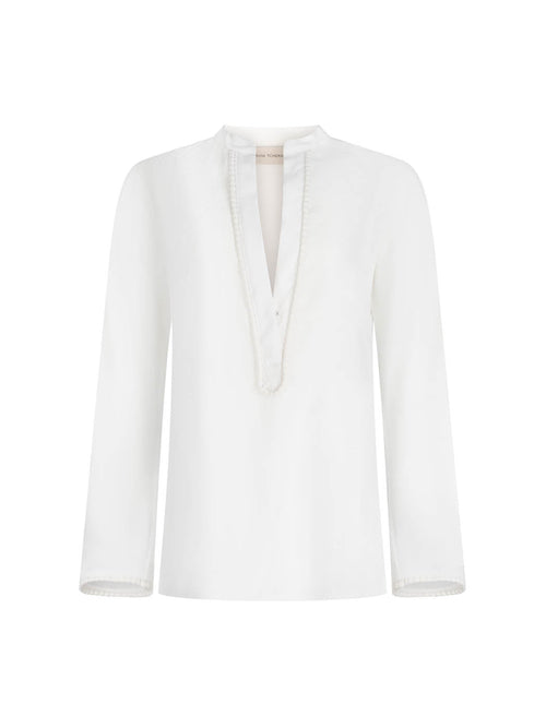 Shera Blouse White with a v-neckline and long sleeves, displayed on a plain background.