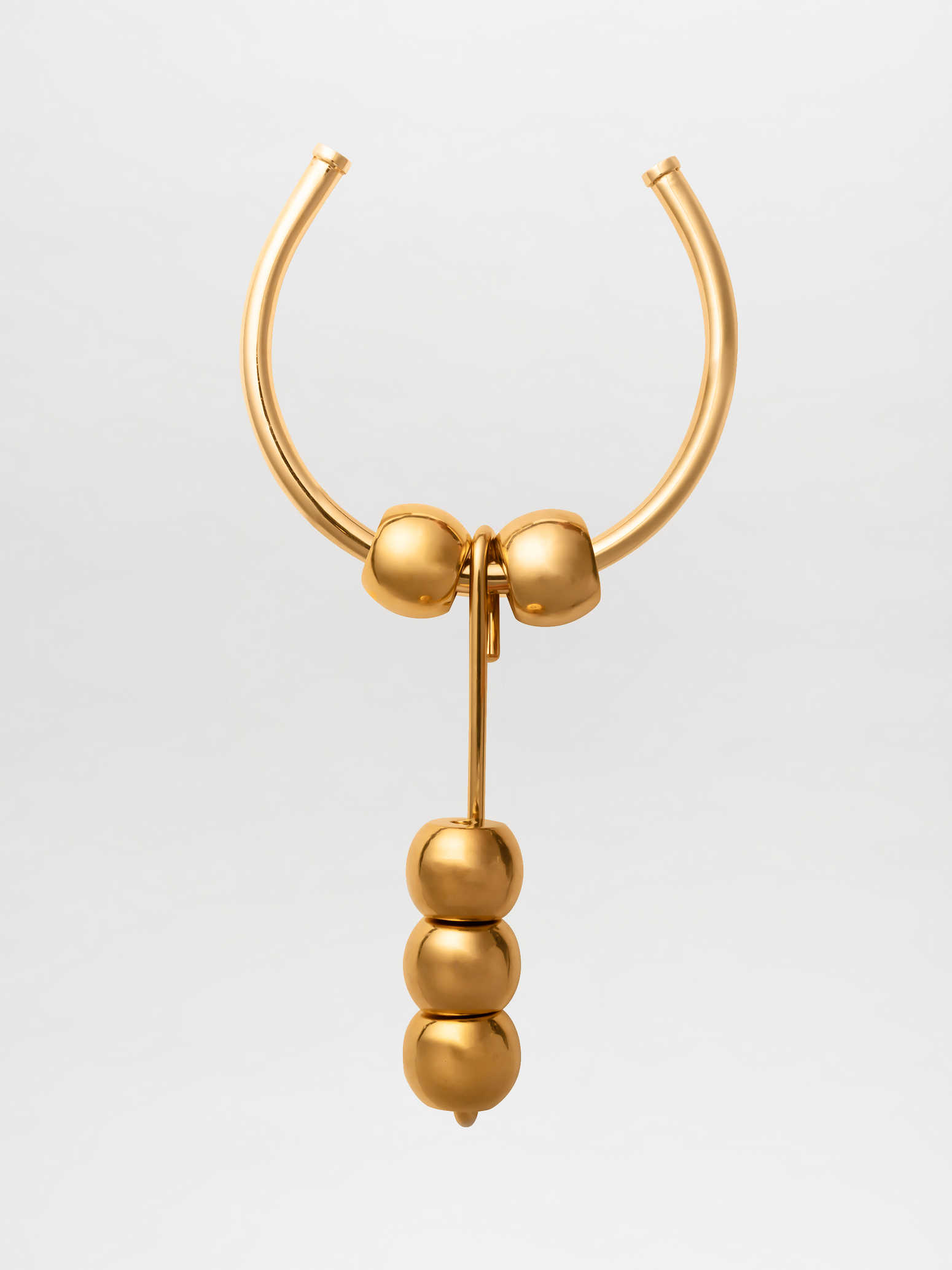 The Tahirah Necklace Gold, featuring two arching rods at the top with four spherical elements hanging below, is now available for pre-order.