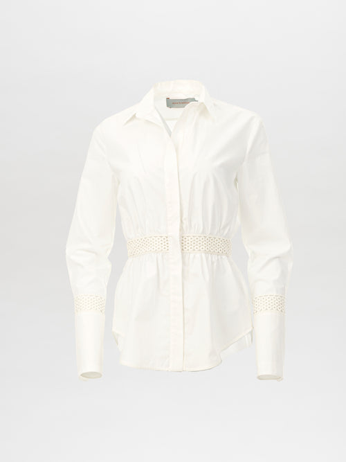 The Tiffany Blouse White by SilviaTcherassiEU is a long-sleeve, collared blouse with lace trim, featuring gathered detailing at the waist and wrists in lightweight fabric against a light background.