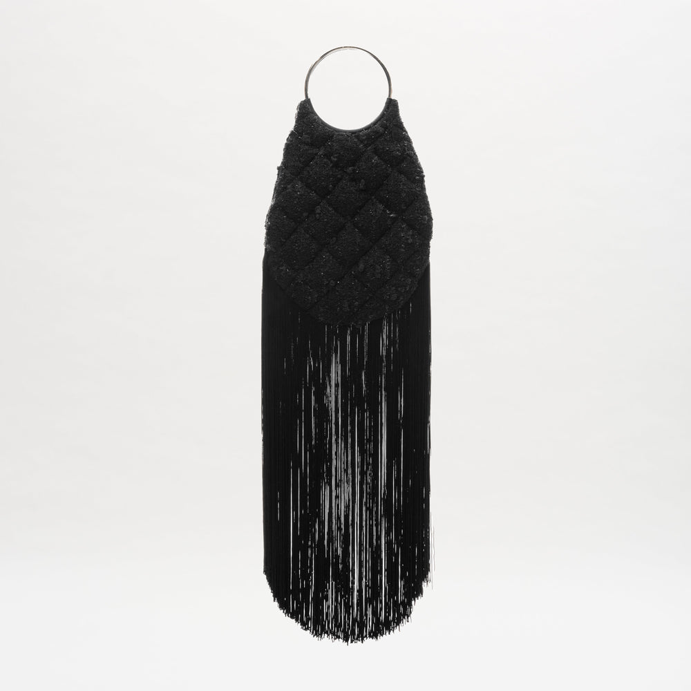 The Toblach Bag by SVT DESIGNS is a black, oval metalized cotton bag with a quilted top, long straight fringe at the bottom, and circular metallic top handles. It's displayed against a plain white background.