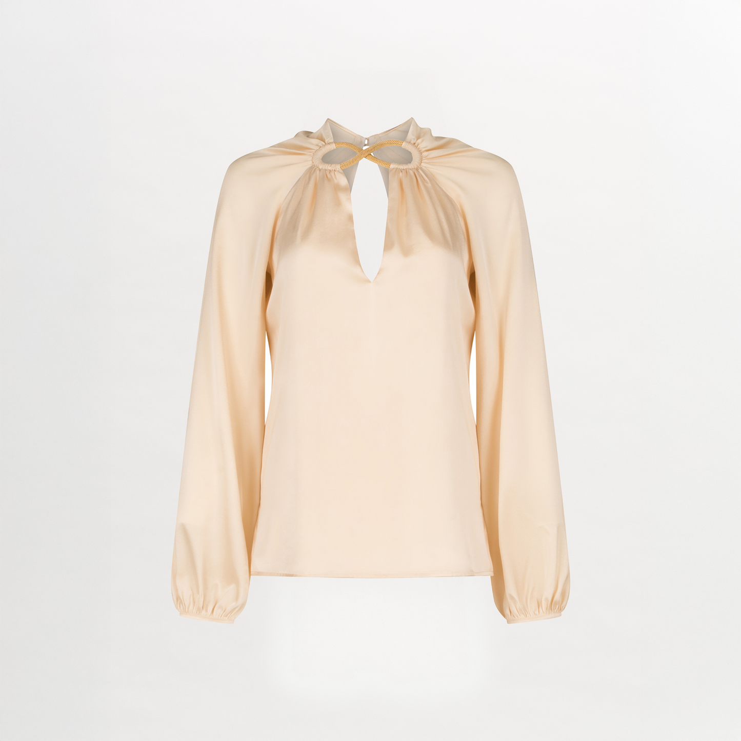 The Ximena Blouse by Silvia Tcherassi US features a silk-like, light beige satin finish, keyhole neckline with two gold accents, and loose gathered long sleeves for an elegant look.