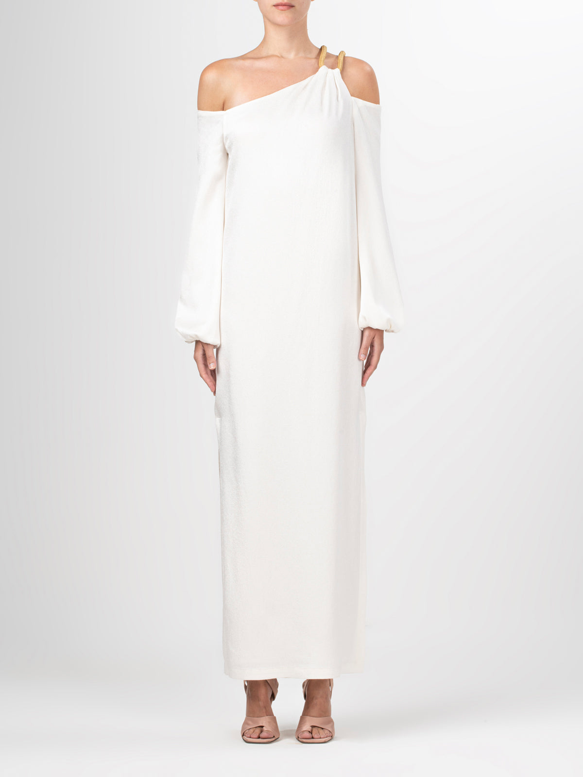 A Ada Dress White with a metallic gold shoulder detail.